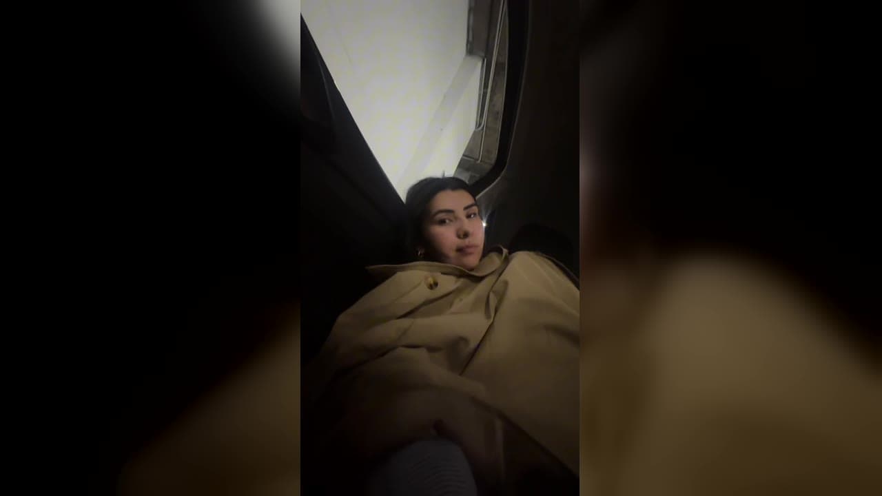 Karol Barbosa enrolada num casaco tentando dormir dentro do carro alugado em Madri