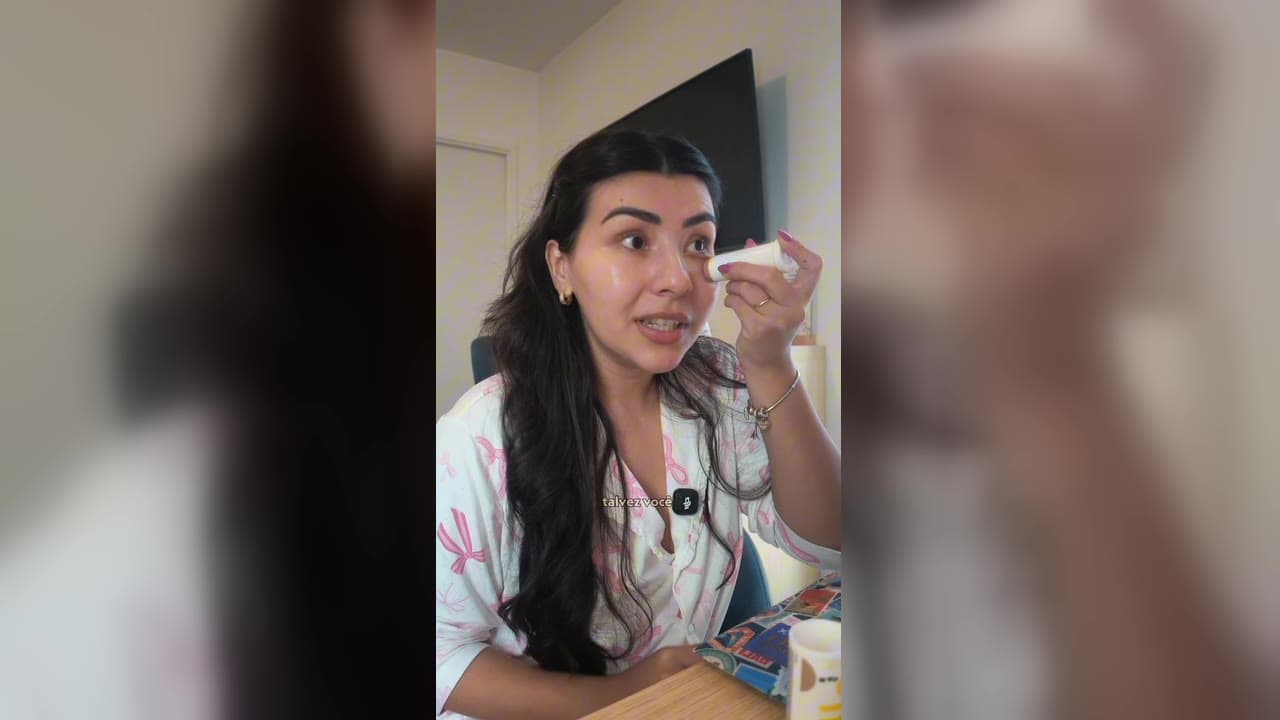Karol Barbosa de pijama passando um bastão de maquiagem com FPS da Ollie no rosto